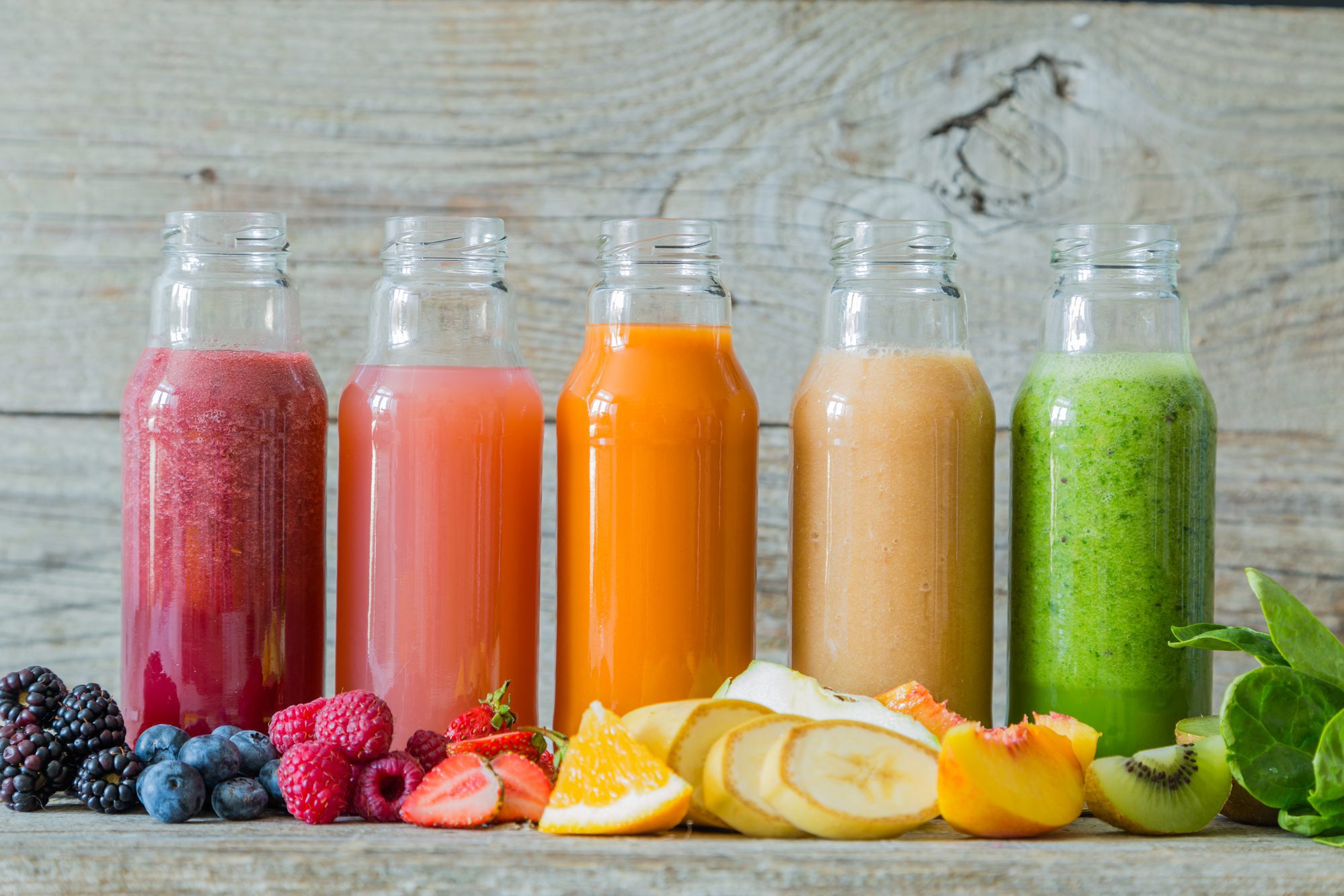 A selection of smoothies that can be used for chakra healing on a rustic background